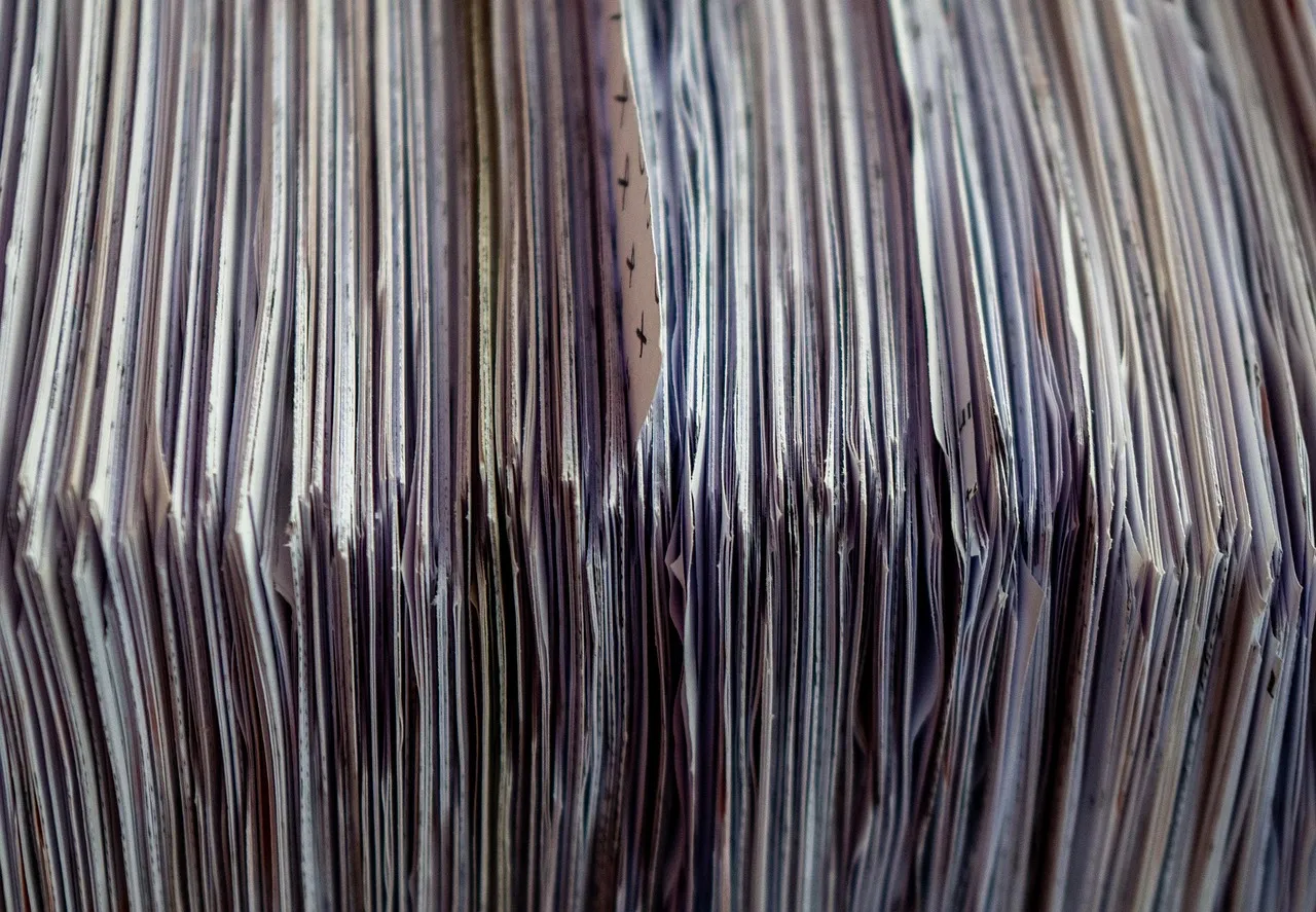 The edges of a tall stack of printed sheets, packed tightly side by side.