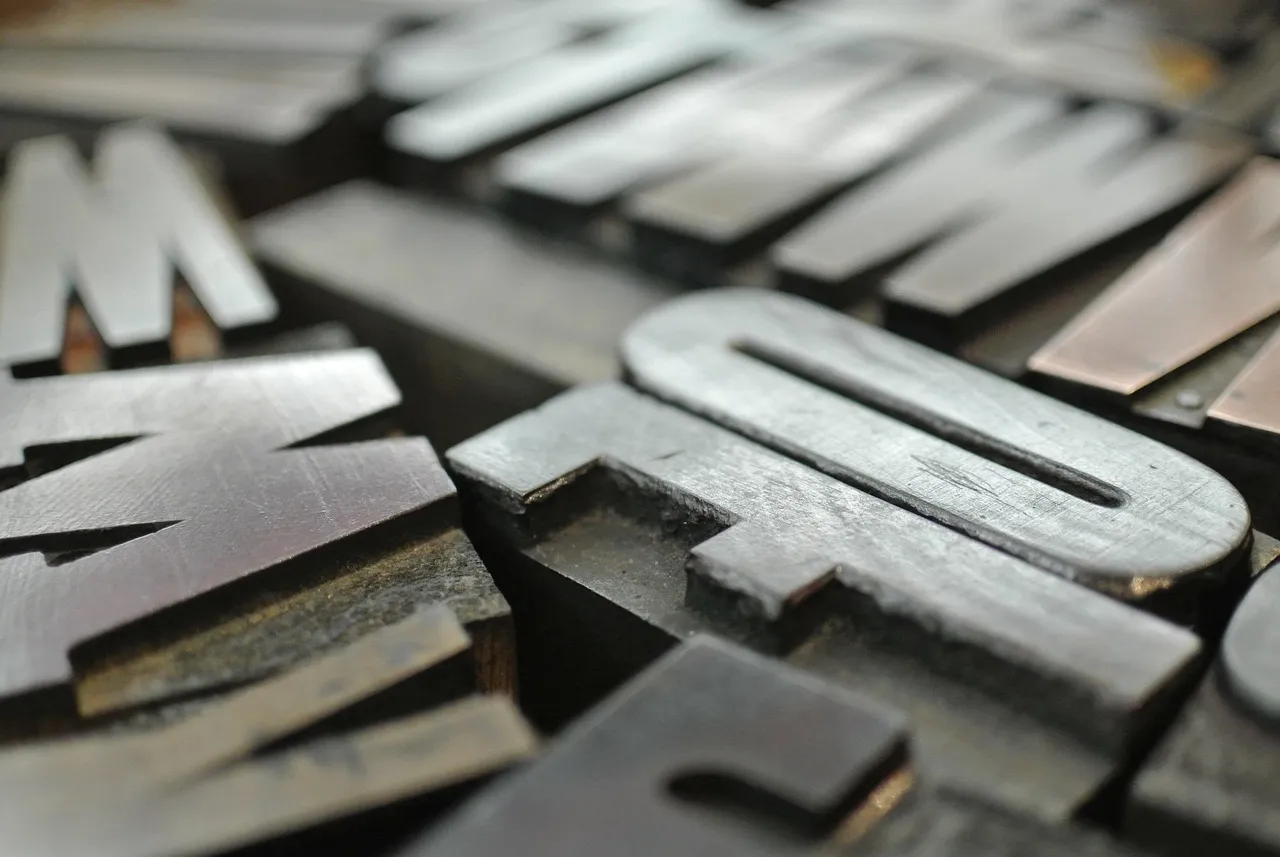Close view of worn metal printing type, letters lying on their sides