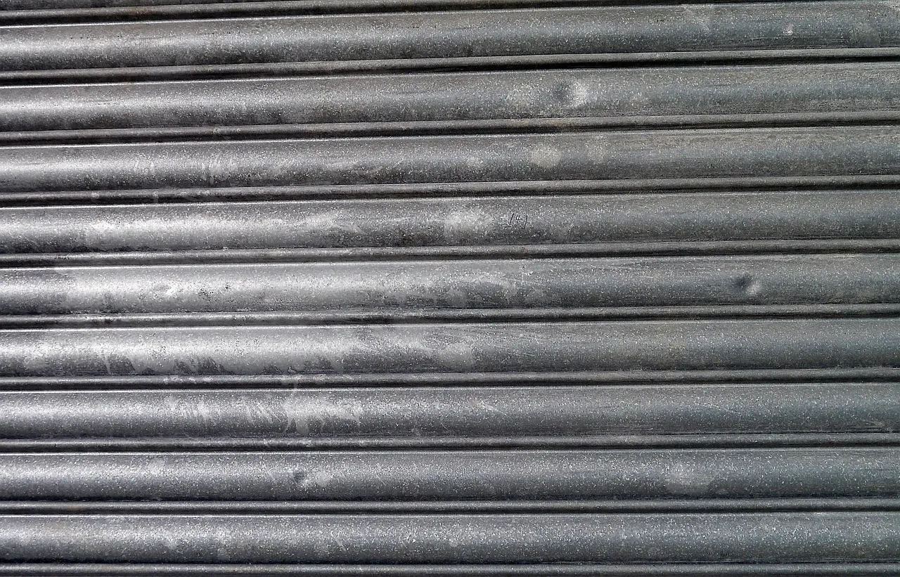 Close-up of a weathered grey steel roller shutter, its horizontal slats scuffed and lightly dented.